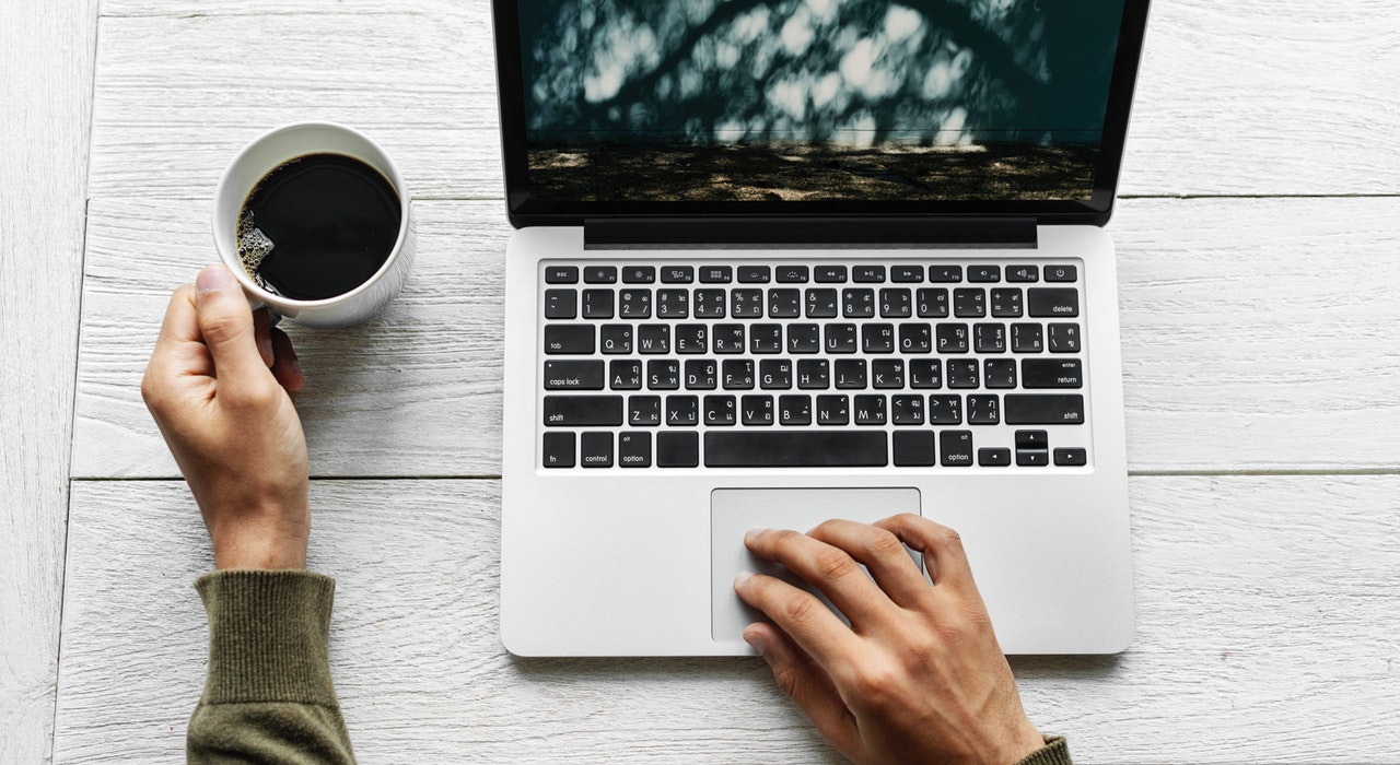 Person on a laptop with a coffee